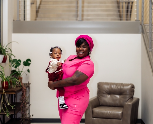 HPC Young Adult Housing Graduate at February 2026 Graduation holding Baby